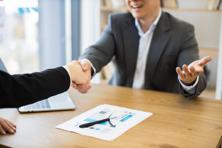 Business handshake during successful contract signing meeting