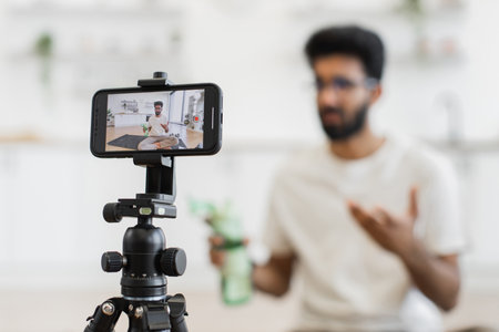 Adult man creating content for video blog discussing fitness and importance of hydrationの写真素材
