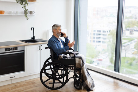 Elderly man sitting in wheelchair in cozy home using smartphone for communication. Bright...