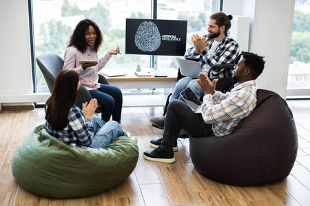 Group of young and diverse colleagues having discussion on AI presentation in office
