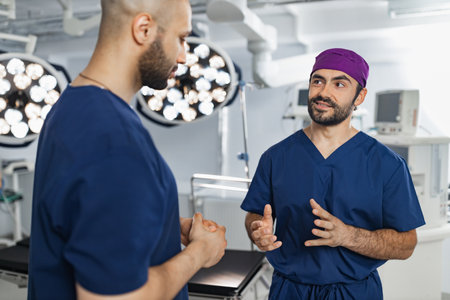 Two surgeons are seen in an operating room, engaged in a discussion, likely planning or reviewing a procedure.の写真素材
