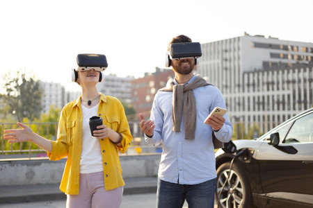 A couple wearing VR headsets near an electric vehicle while its charging, suggesting a futuristic...