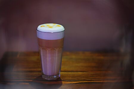 Glass of latte on a wooden tableの写真素材