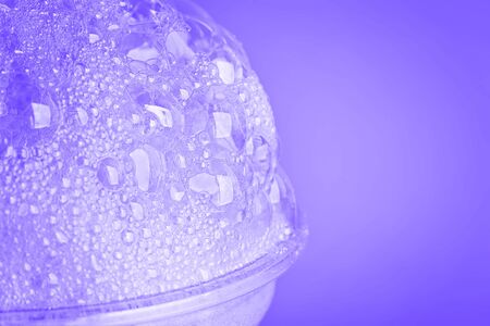 Oxygen cocktail foam in a plastic glass on a bright pink background with a sprig of mintの写真素材