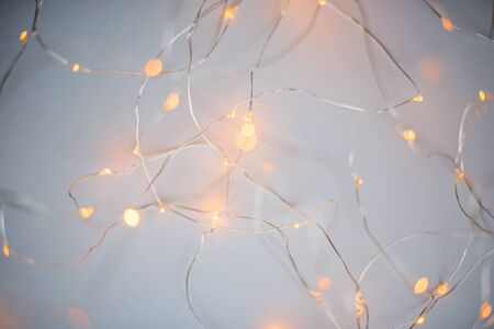 Blurry luminous warm white garland on the white background. New Year Christmas background.の写真素材