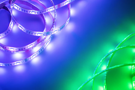 Bright neon LED strip glows purple, violet and green. Copyspace.