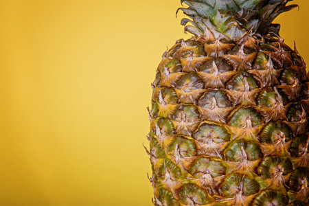 Ripe pineapple close-up on a yellow background.