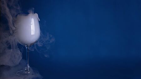 Large wine glass with smoke on a blue background. Color of the year 2020, Classic Blue.の写真素材