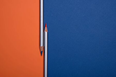 Classic blue and orange pencils on a blue and orange paper. Place for text. Copy space.の写真素材