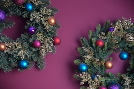 New Year decoration. Christmas background. Coniferous wreaths with balls on a purple background.の写真素材