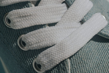 Blue sneakers with white laces on a light blue background. Trendy fashionable casual concept.