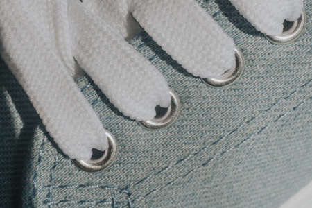 Blue sneakers with white laces on  light blueの写真素材