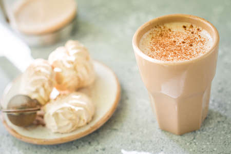 A drink in a ceramic glass and a cake on the table. Nice breakfast.の写真素材