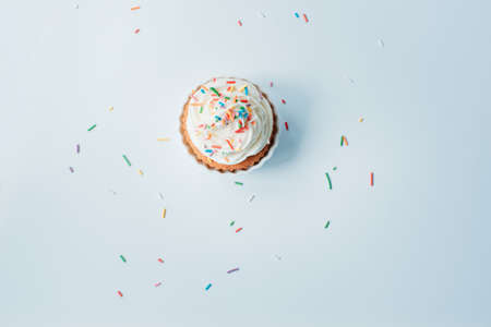 Homemade cupcake with colorful sprinkles on a white background.の写真素材