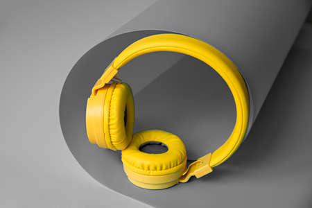 Yellow wireless headphones on gray creative background.の写真素材
