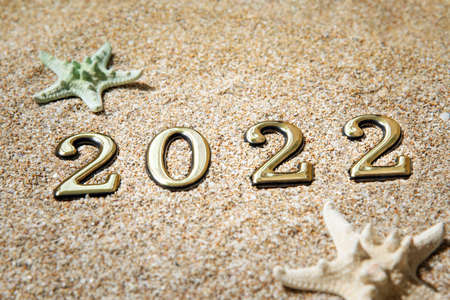 Golden numbers 2021 and starfish on the sand by the sea.の写真素材