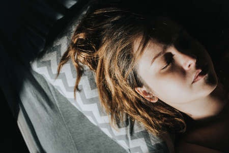 Portrait of a sleeping caucasian woman in the morning sun.の写真素材