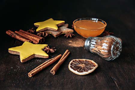 Composition of Christmas gingerbread in the shape of stars, spices and honey on a wooden table.の写真素材