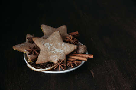 Christmas gingerbread in the shape of stars, spices and honey on a wooden table.の写真素材