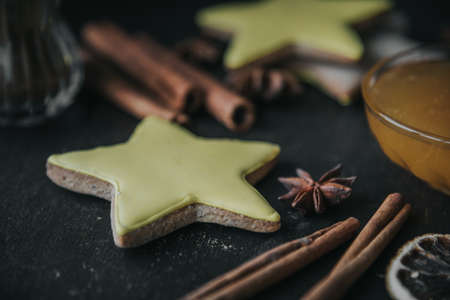 Christmas gingerbread in the shape of stars, spices and honey on a wooden table.の写真素材
