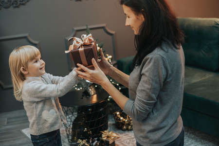 Mom and little daughter give gifts to each other.の写真素材