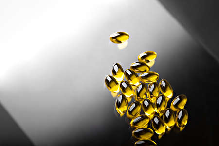 Omega 3 fish oil transparent capsules on black and white backgroundの写真素材