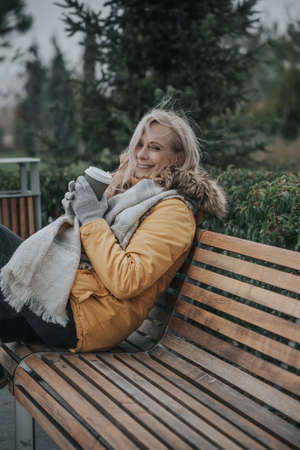Aged pretty woman with blond hair drinks coffeeの写真素材