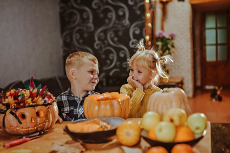 Boy and girl fool around decorating Halloween pumpkins.の写真素材