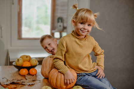 Boy and girl fool around decorating Halloween pumpkins.の写真素材