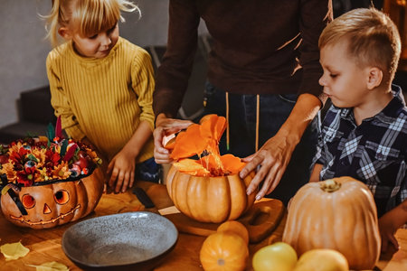 Boy and girl fool around decorating Halloween pumpkins.の写真素材