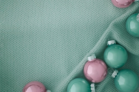 Beautiful Christmas balls in soft pink and mint colors on a knitted mint fabric.の写真素材