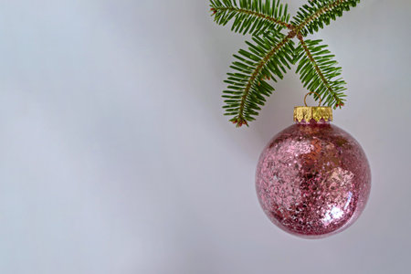 Christmas ball with pink sequins inside, Christmas tree branch on a white background. copyspace. Place for text.の写真素材