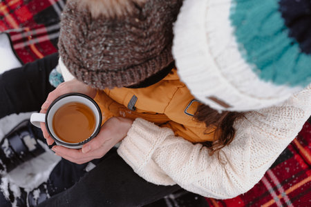 Mother and child on a winter walk outdoors drinking teaの写真素材