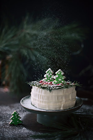 Winter cake with spruce-shaped gingerbread sprinkled with powdered sugar. Christmas treat.の写真素材