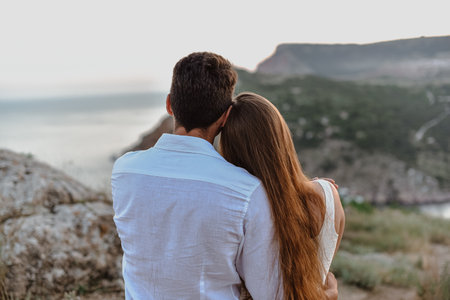 Beautiful young loving couple man of Middle Eastern appearance and a Caucasian woman hug, kiss at sunrise. outdoor love story.の写真素材