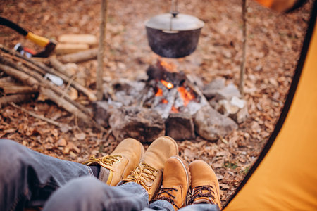 Dad and son are sitting in a tent by the fire. View from the tentの写真素材