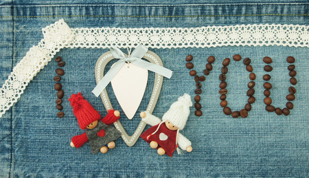 Valentine, greeting card with wooden white heart,coffee beans and knitted loving couple man and woman.の写真素材