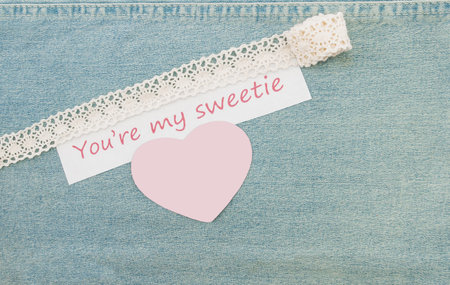 Valentine greeting card with blank heart and lettering You’re my sweetie on the denim background.