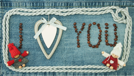 Valentine, greeting card with wooden white heart, coffee beans and knitted loving couple man and woman.の写真素材
