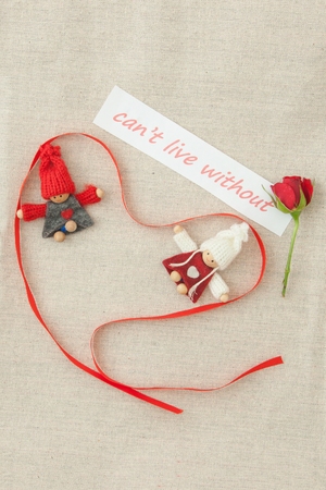 Valentine, greeting card with red little rose and red ribbon in the shape of a heart.の写真素材