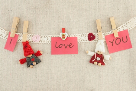 valentine, greeting card. Wooden pins, red and pink hearts, knitted loving couple man and womanの写真素材
