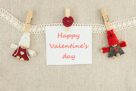 Valentine, greeting card. Wooden pins, knitted loving couple man and woman, red heartの写真素材