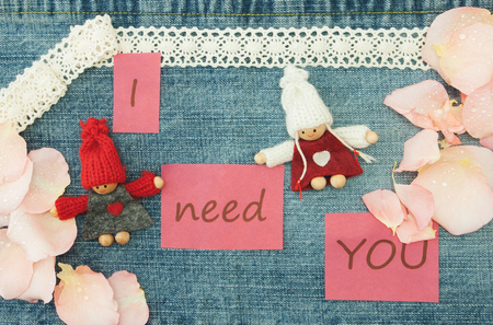 Valentine, greeting card with knitting couple in love and soft pink rose petals.の写真素材