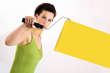 Woman painting on wall using paint rollerの写真素材