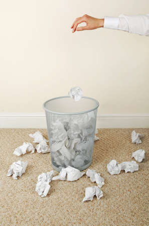 Woman throwing paper in waste paper bin, close-up of hand の写真素材