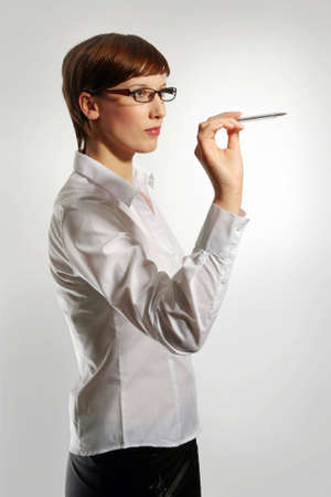Young business woman wearing glasses, holding up pen の写真素材