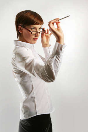 Young woman wearing glasses, holding up pen の写真素材