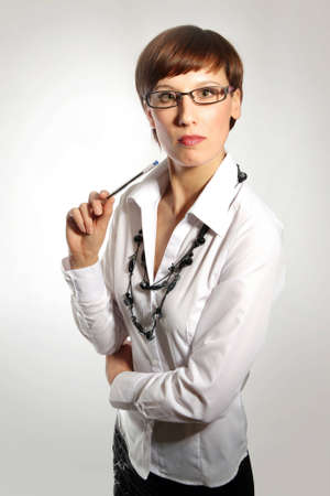 Young business woman wearing glasses, holding pen の写真素材