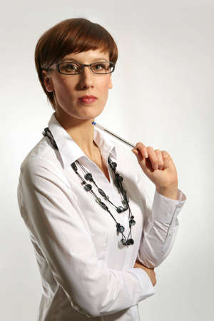 Young business woman wearing glasses, holding pen の写真素材