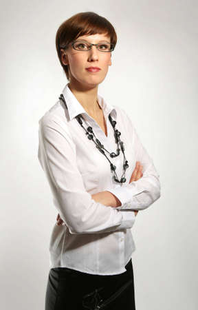Sexy young business woman wearing glasses, arms crossed, portrait の写真素材